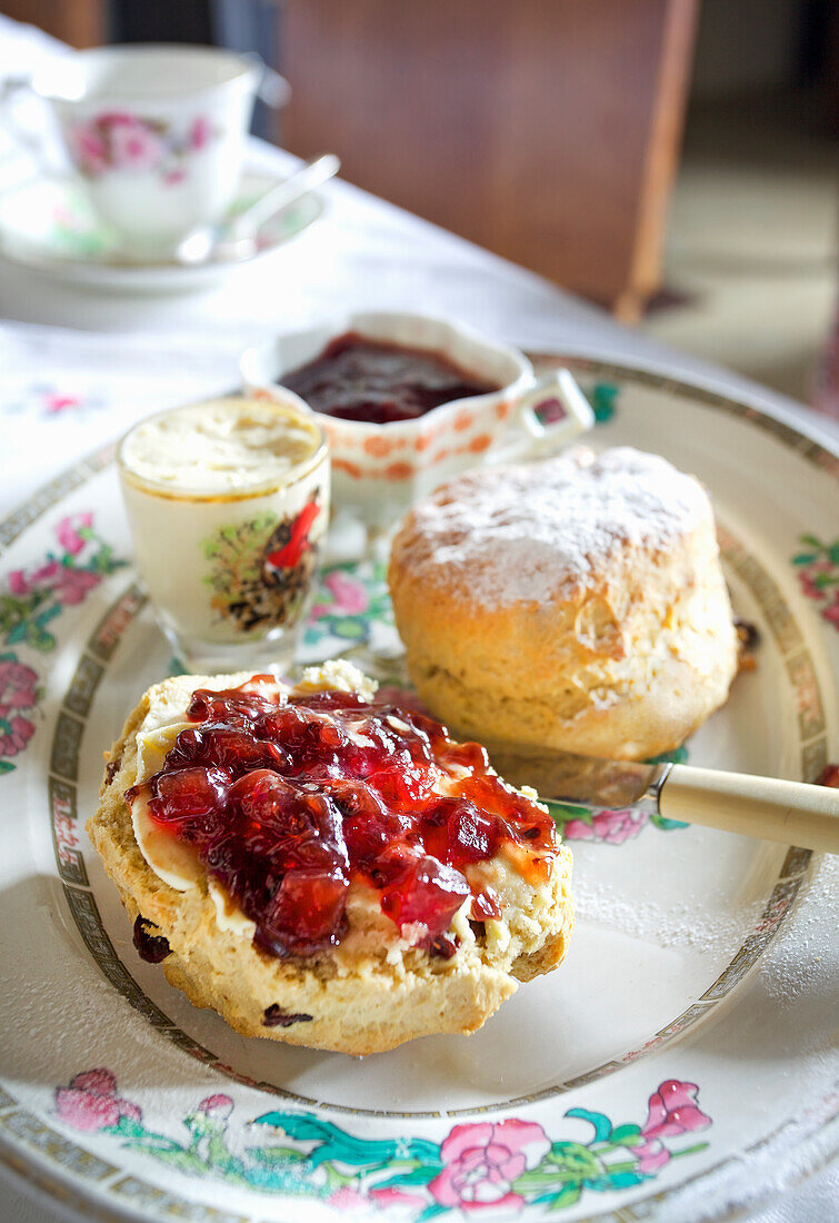 Scones mit Marmelade auf Blümchen-Geschirr im Vintage-Stil