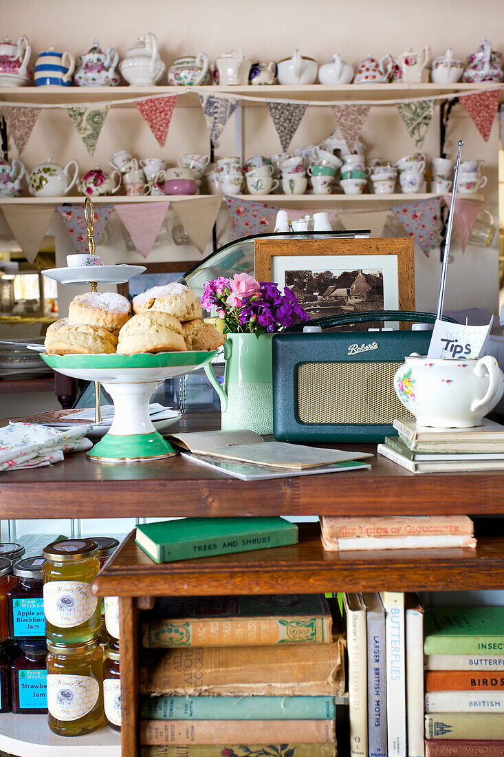 Cafe interior in vintage style with teapots, cups, scones on a cake plate and old radio