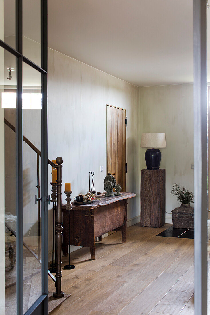 Entrance area with rustic console and modern glass door