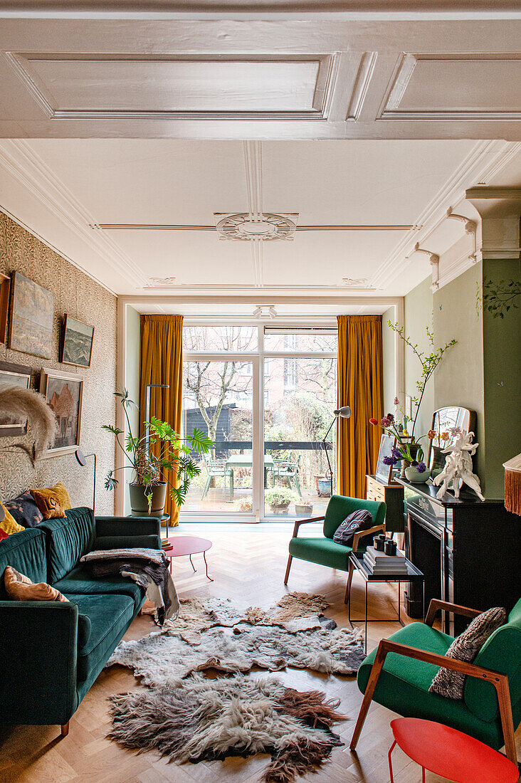 Living room with wooden parquet flooring, velvet sofa and fur rugs, view of terrace