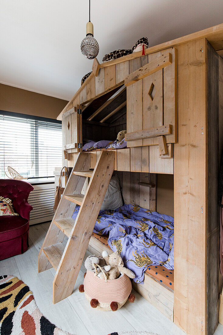 Holzhochbett mit Leiter und Diskokugel im Kinderzimmer