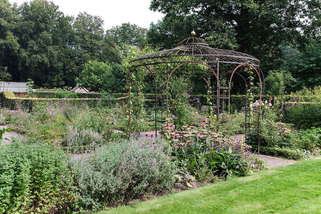 Gartenpavillon aus Metall mit Wildblumenbeet im Sommergarten