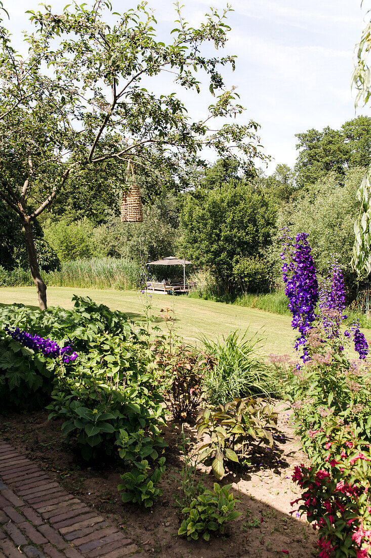 Flowering garden landscape, seating area in the background