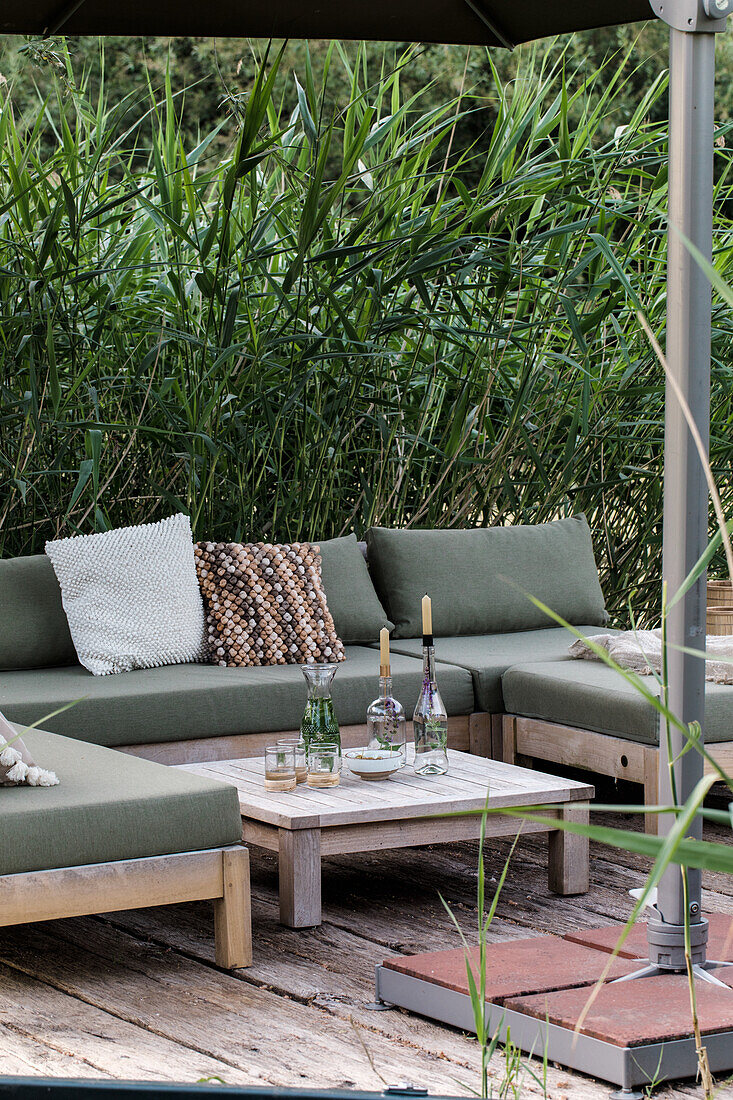 Terrassenbereich mit Loungemöbeln und Bambus im Garten