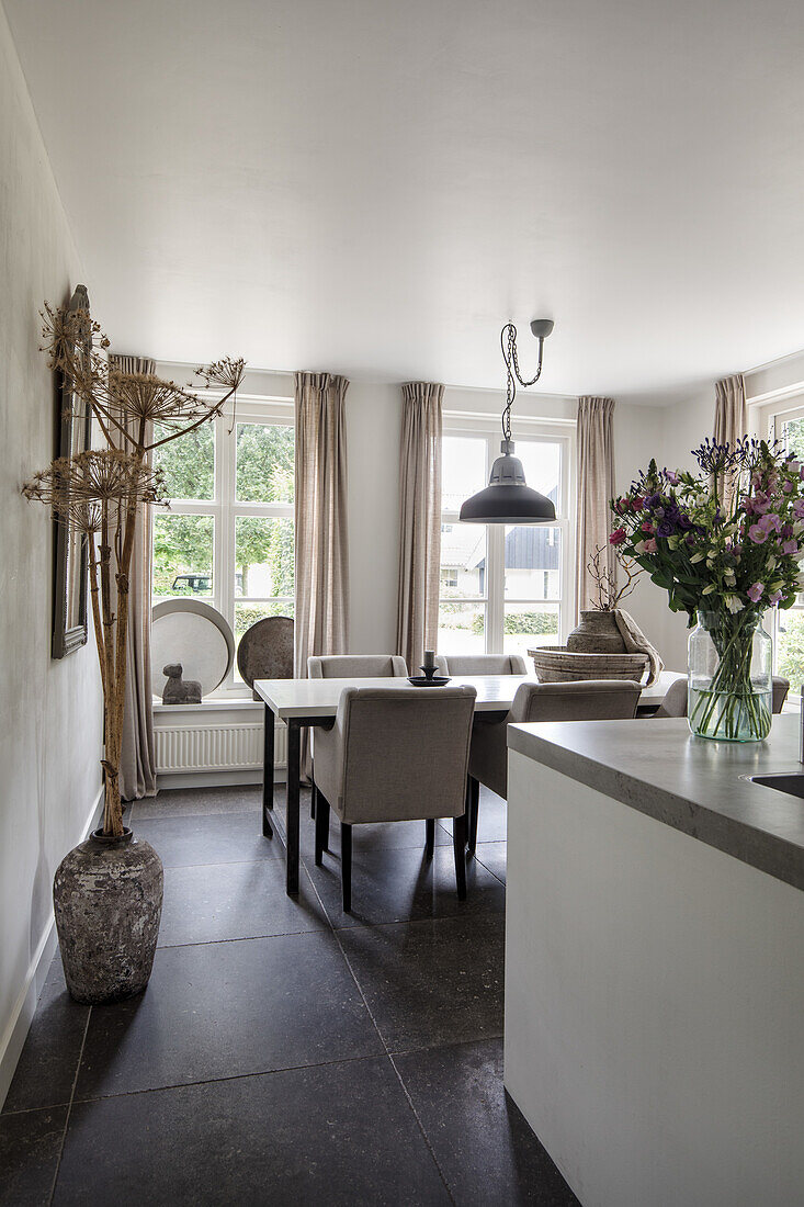 Dining area with dark stone tiled floor and pendant light