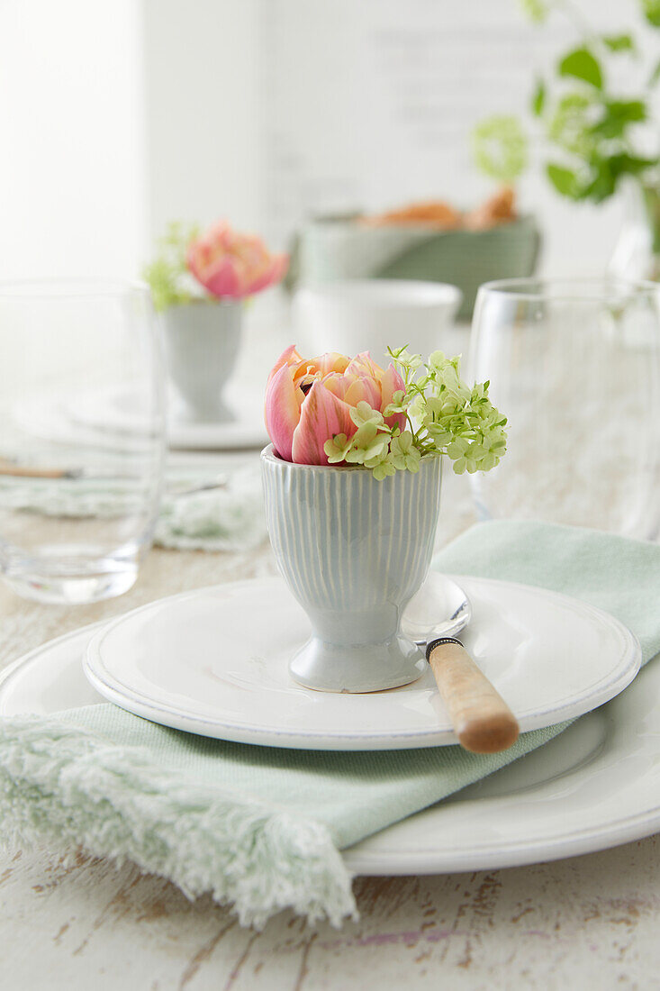 Pastel-colored flowers in an egg cup as table decorations