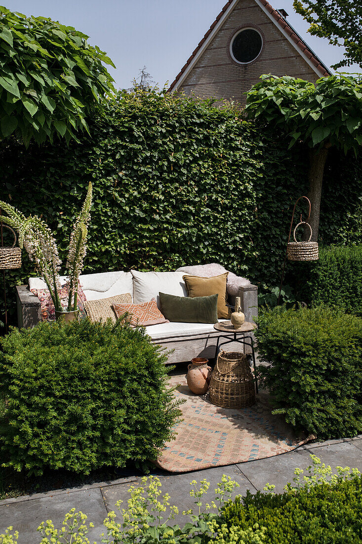 Seating area in the garden with throw pillows and rattan baskets