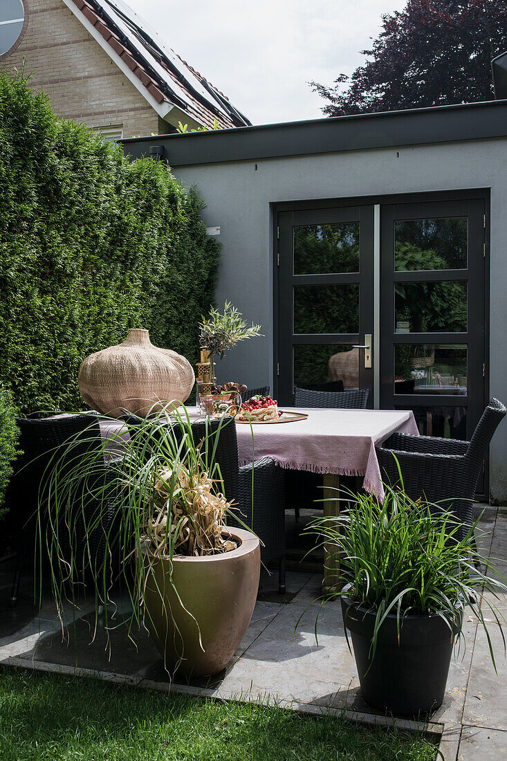 Terrassentisch mit Pflanzen in modernem Gartenbereich