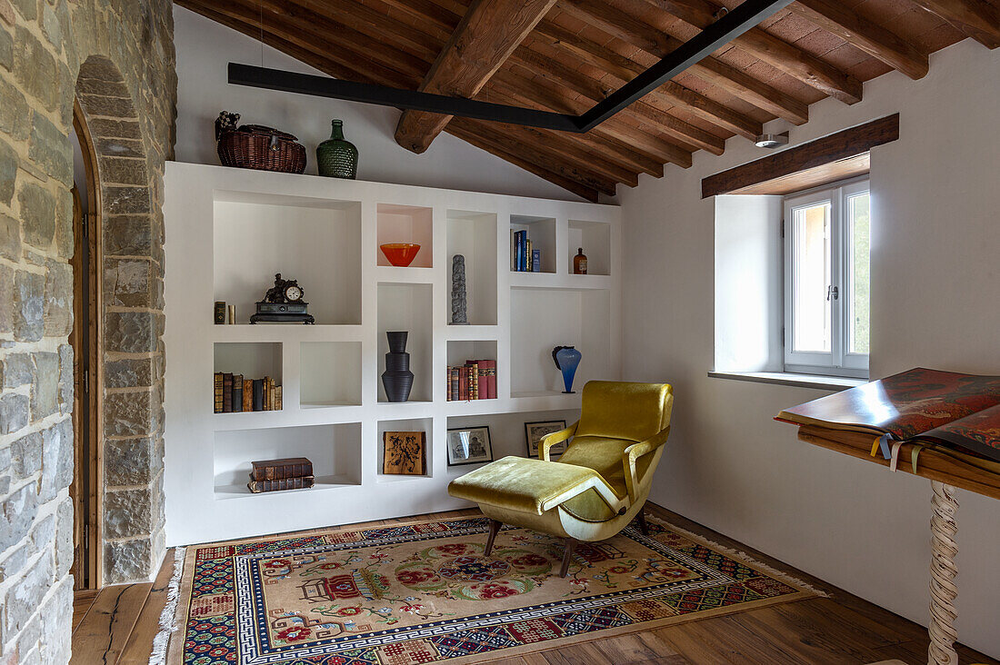 Cozy reading area in rustic living room with built-in shelving and recliner chair