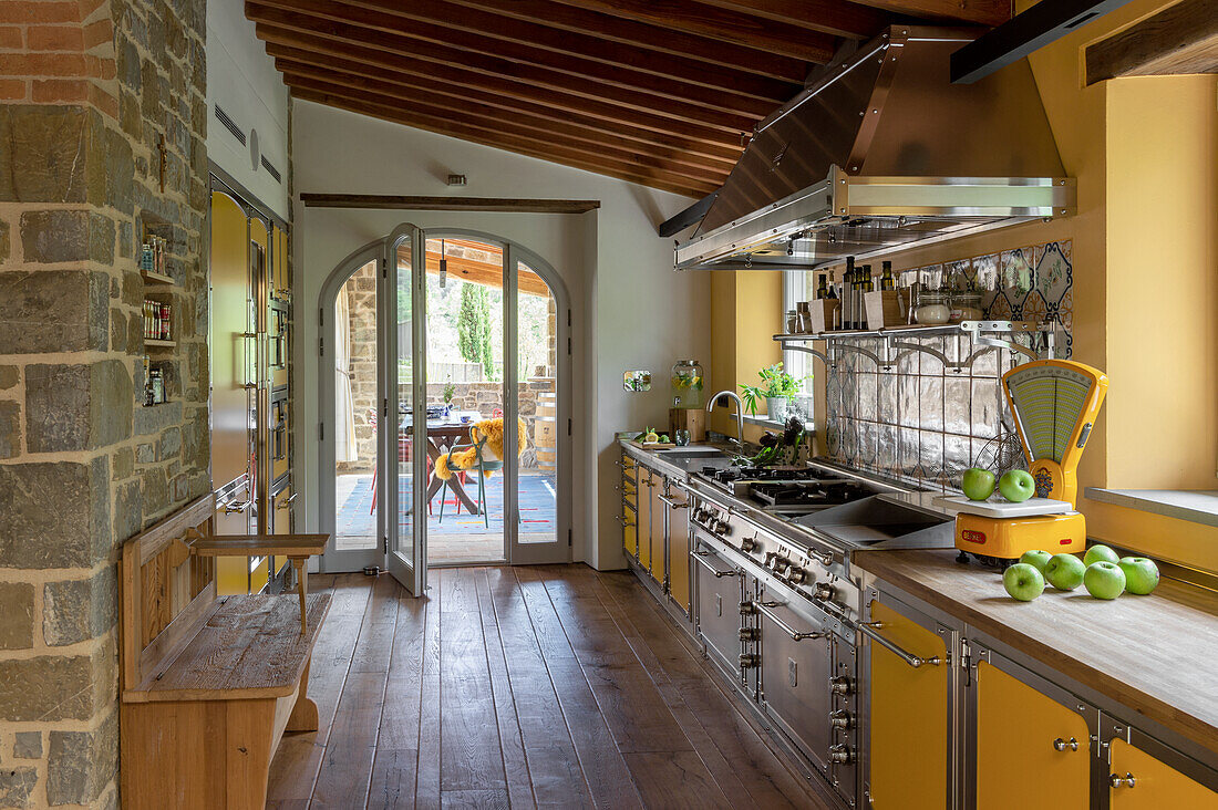 Country-style kitchen with yellow cupboards and walls