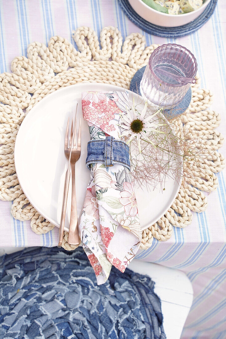 Table setting with crocheted placemat, floral napkin and copper cutlery