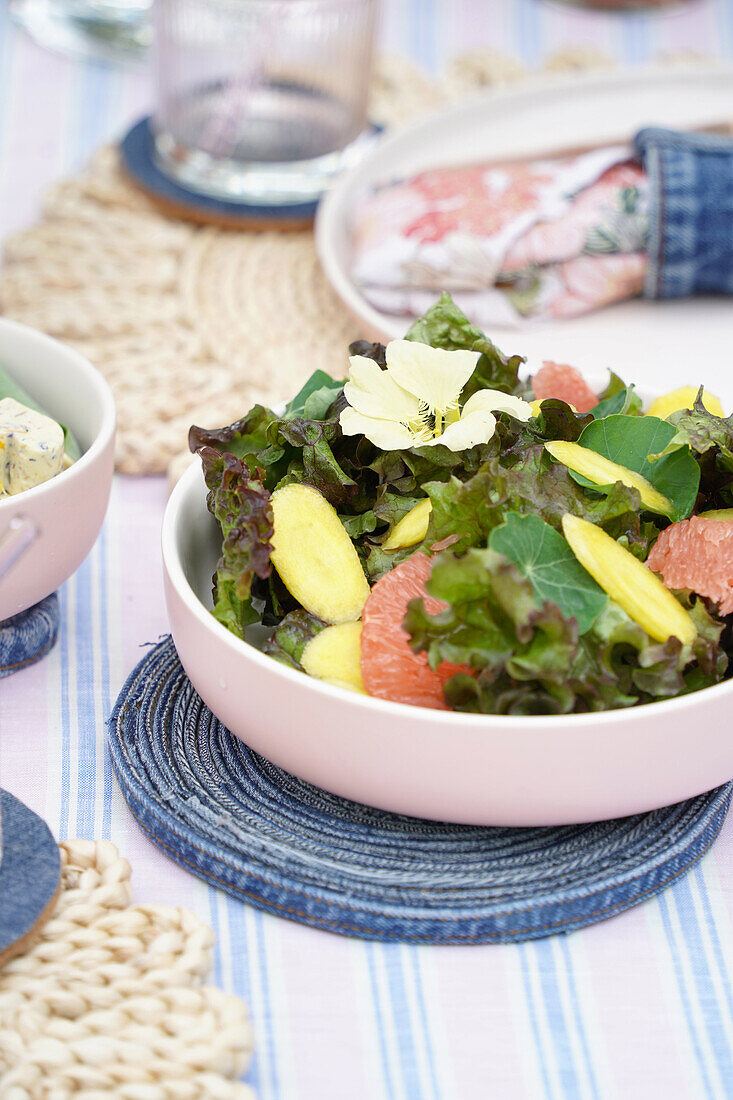 Bunter Salat mit Grapefruit auf hübsch gedecktem Tisch