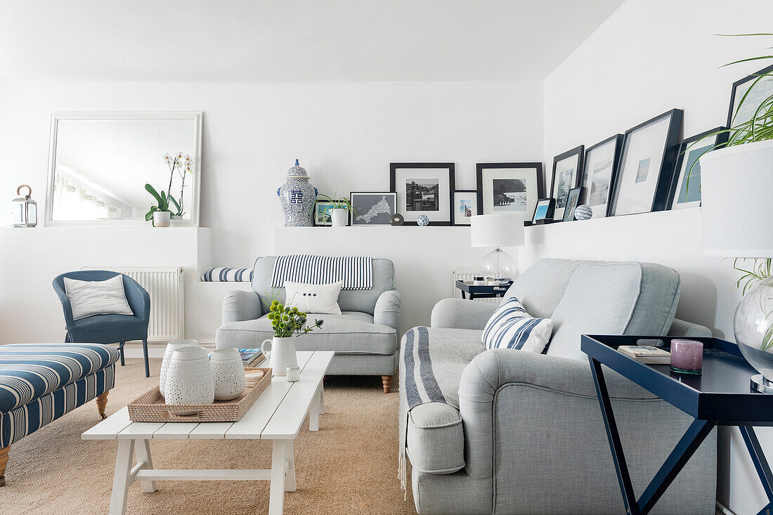 Bright living room with light blue sofas, striped stool and striped cushions