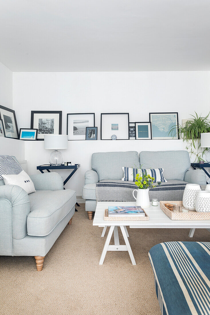 Living room with light blue sofas, striped cushions and pictures