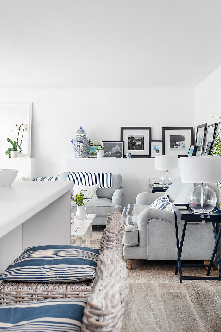 Open-plan kitchen and living area with sofas, bar stools and blue accents