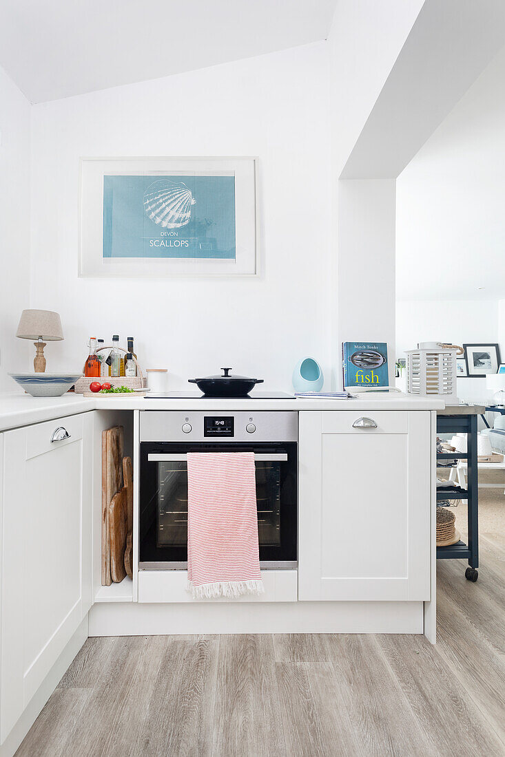 White kitchen with wooden floor and maritime mural