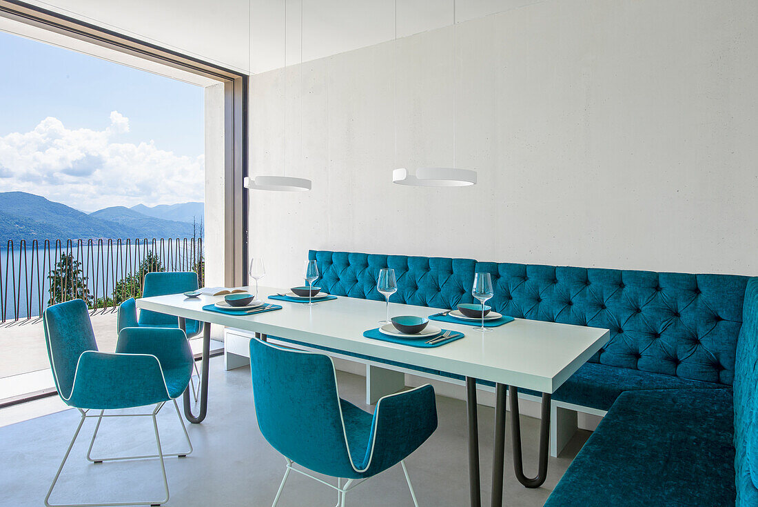 Dining area with turquoise upholstered seating and lake view