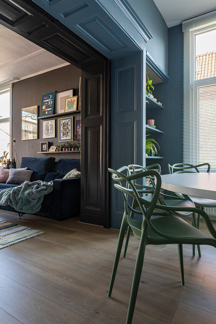 Modern dining area with green plastic chairs, view into the living room