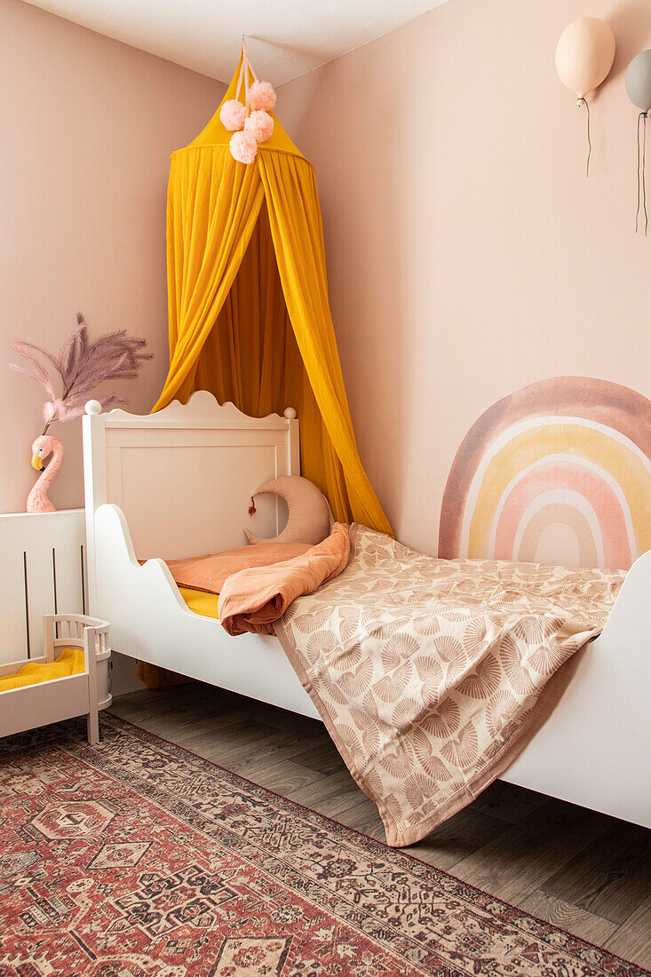 Children's room with yellow accents and rainbow wall decorations