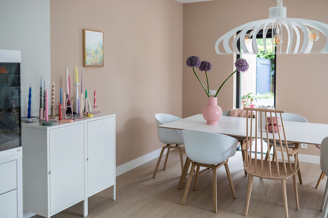 Dining room with colorful candles and flowers in a pink vase