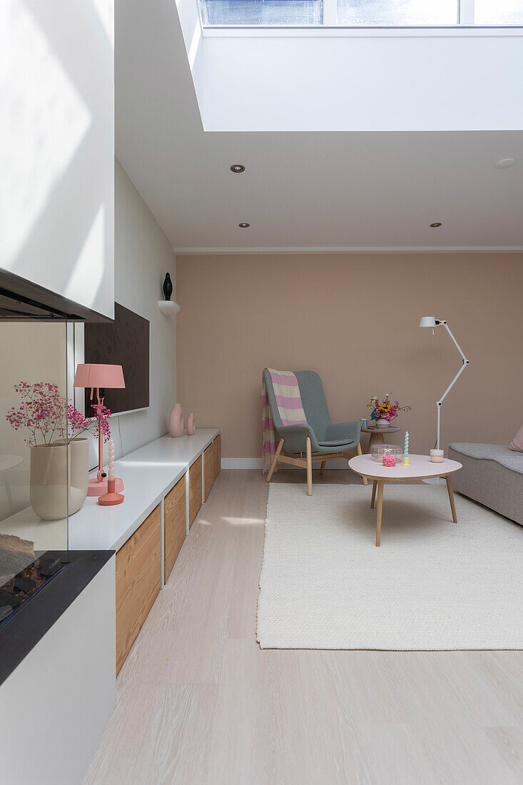 Light-flooded living room with skylight, pastel-colored decor and wooden accents