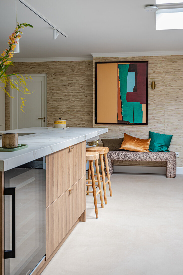 Modern kitchen with cooking island and seating area in front of abstract wall art