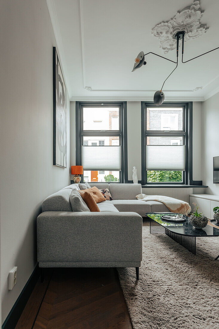 Modern living room with grey corner sofa and sculptural ceiling light