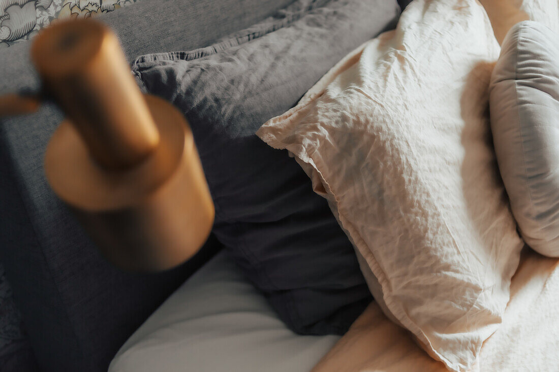 Pillows and blankets in neutral colors on a bed