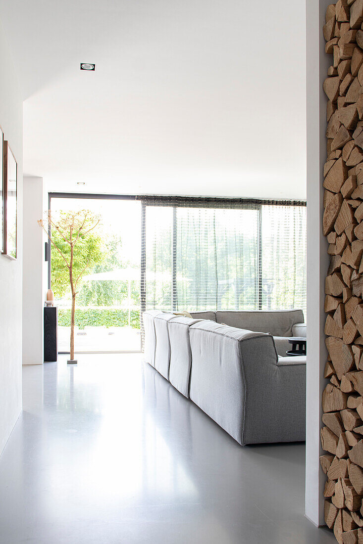 Modern, bright living area with grey sofa and floor-to-ceiling windows