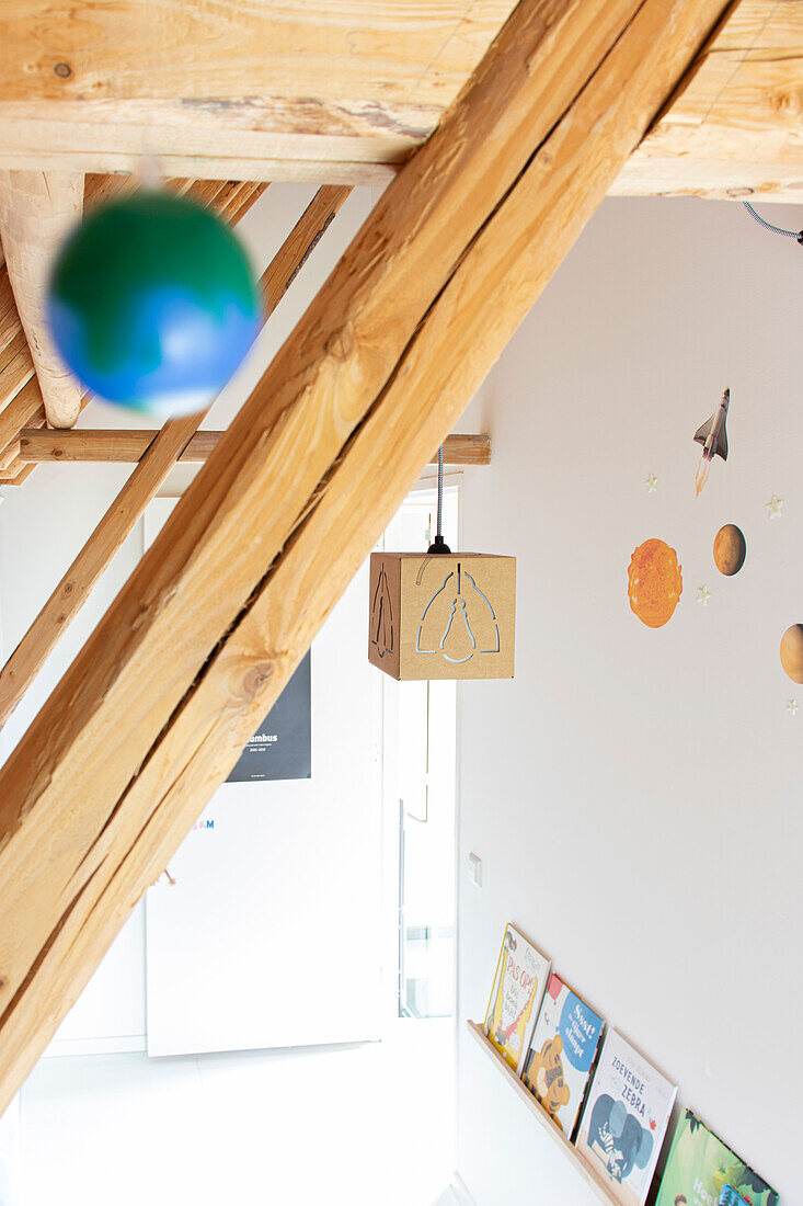 Attic children's room with wooden beams and space decoration