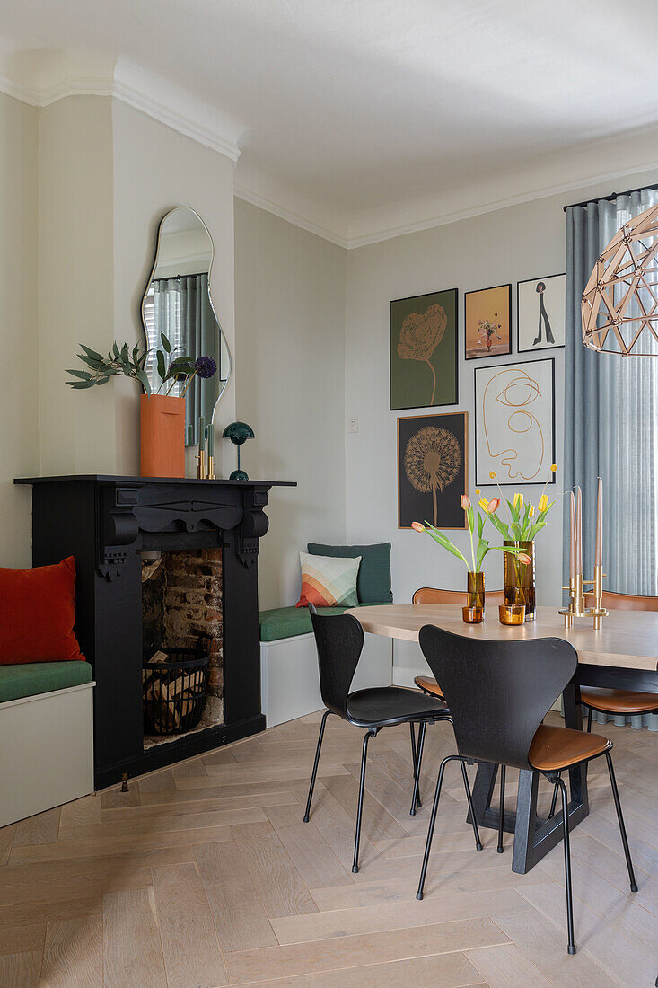 Dining room with black fireplace, wooden floor and gallery wall