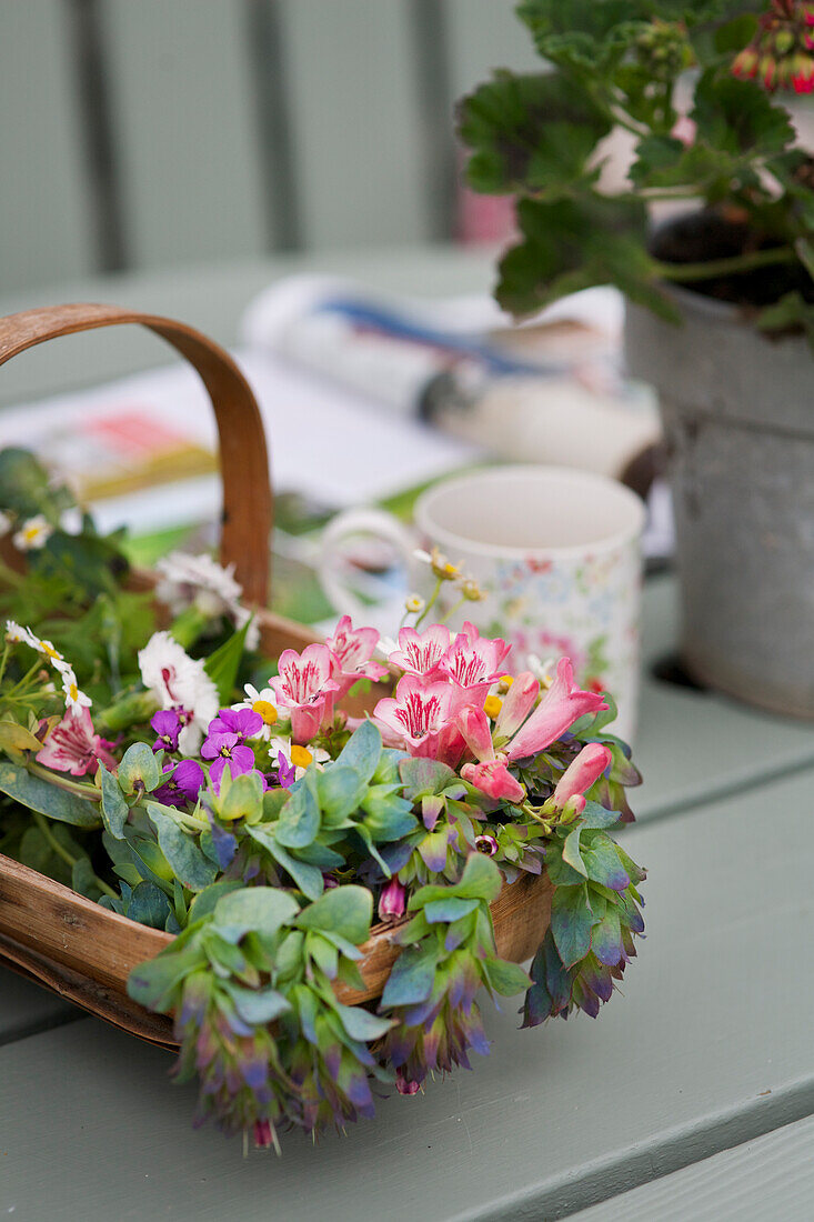 Flower arrangement in a basket on a garden table