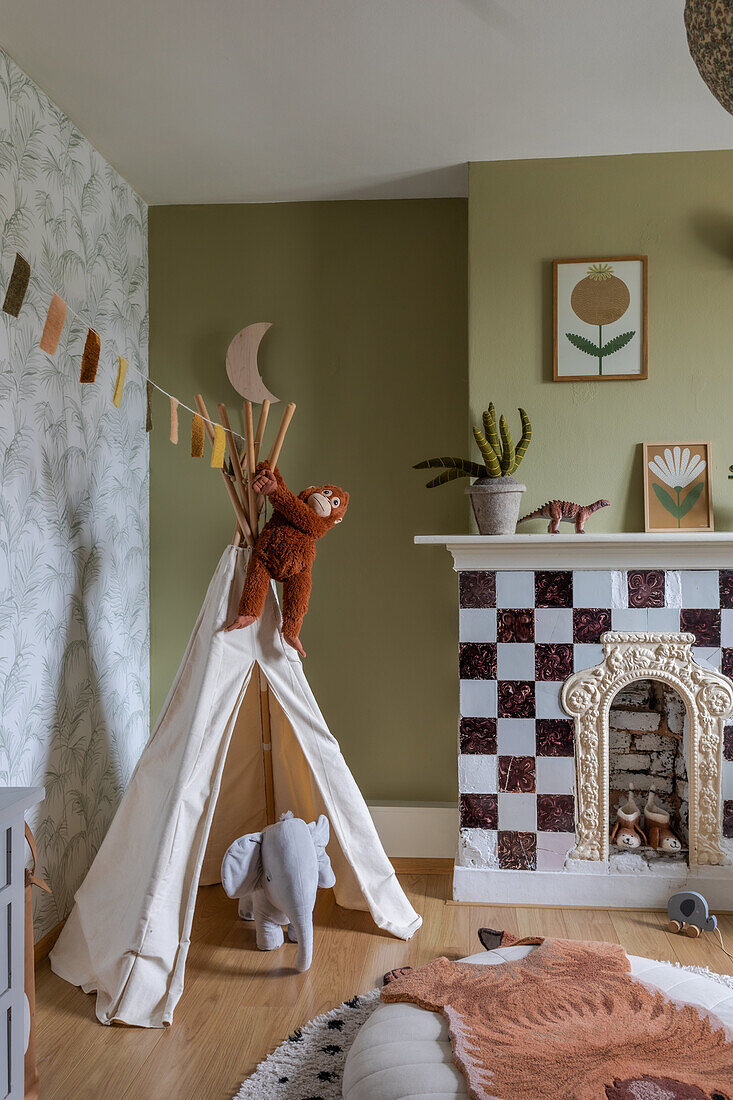 Children's room with teepee tent, elephant toy and fireplace with checkerboard tiles