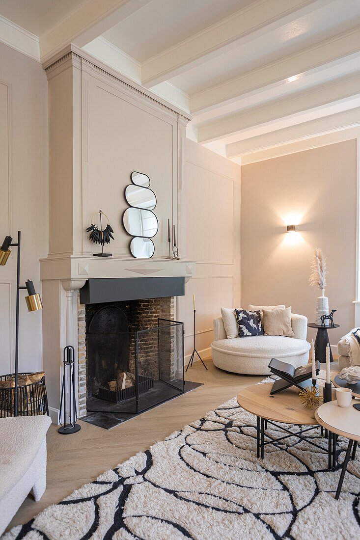 Living room with fireplace, round mirrors and light-colored furniture