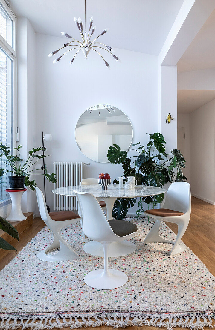 Round marble table with white tulip chairs in modern dining room