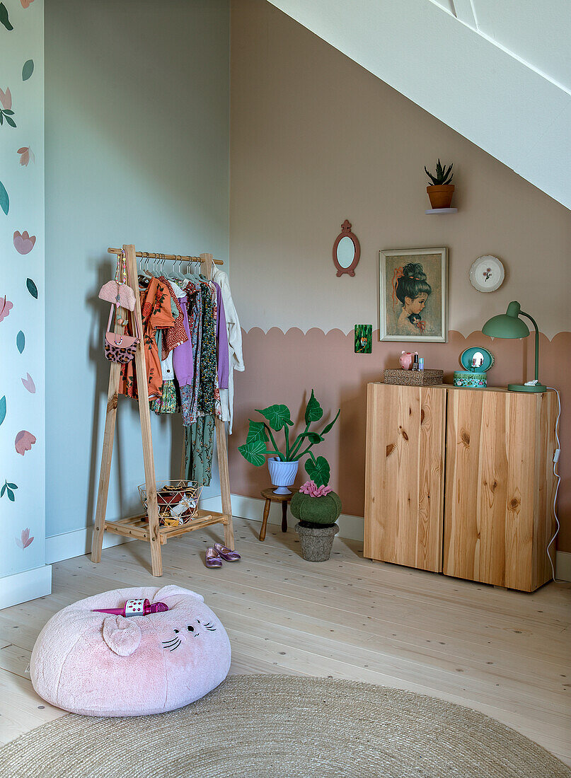 Children's room with wooden wardrobe, clothes rack and seat cushion