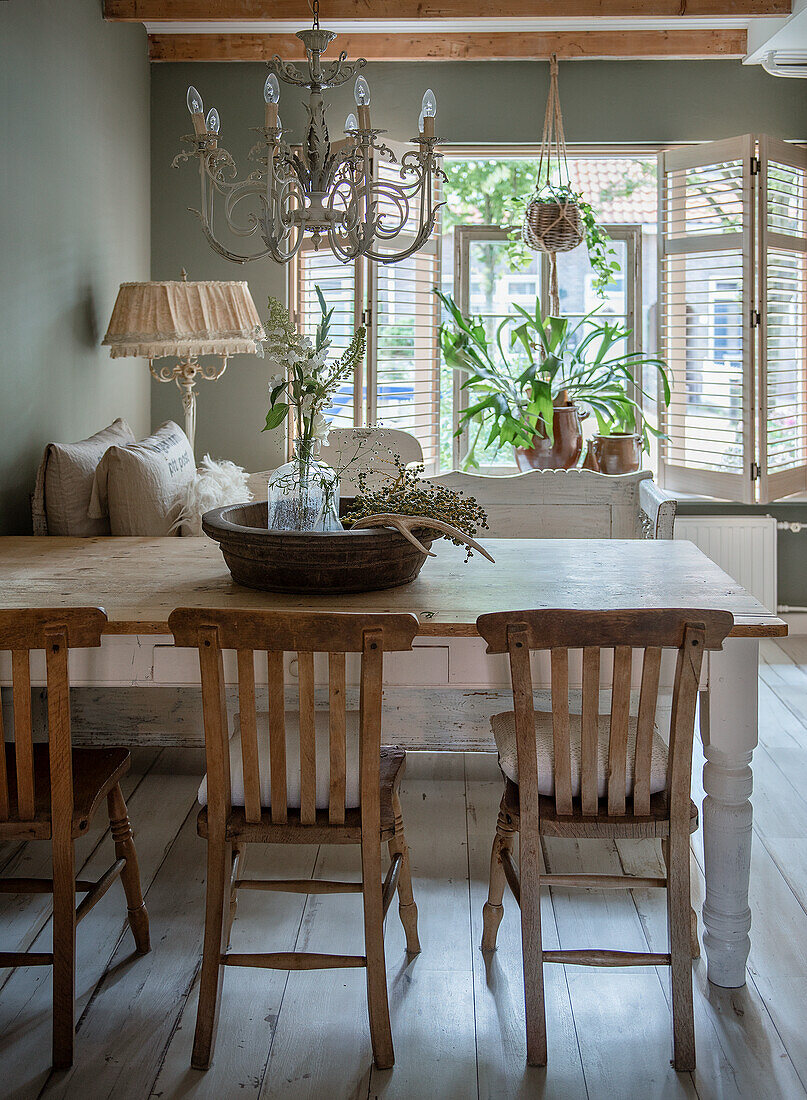 Esszimmer mit rustikalem Holztisch, Vintage-Stühlen und Kronleuchter