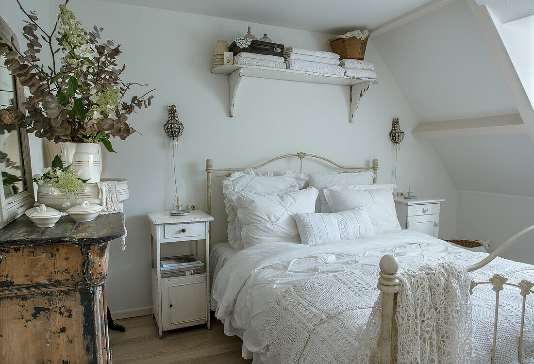 Schlafzimmer im Landhausstil mit weißen Möbeln und gehäkelter Bettdecke