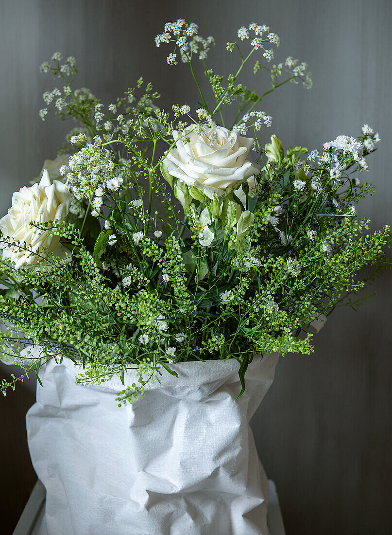 Blumenstrauß in Weiß und Grün in Papierverpackung