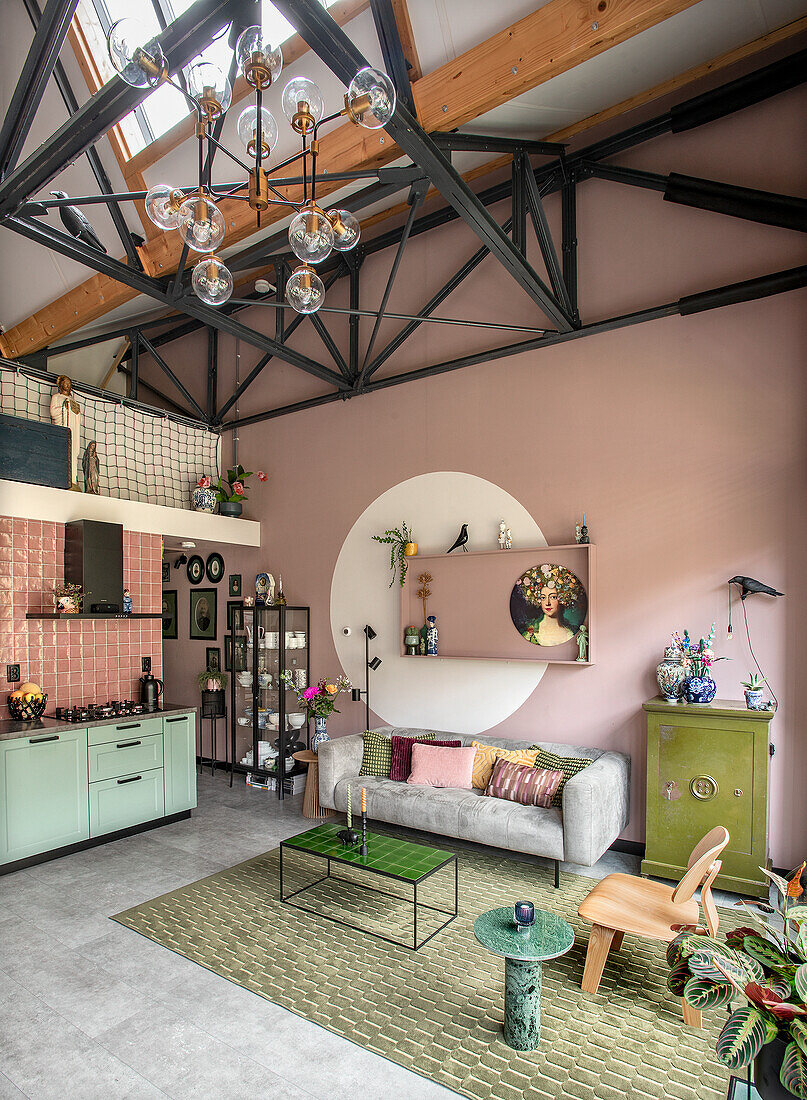 Living room with high ceilings, open-plan kitchen and pink accent wall