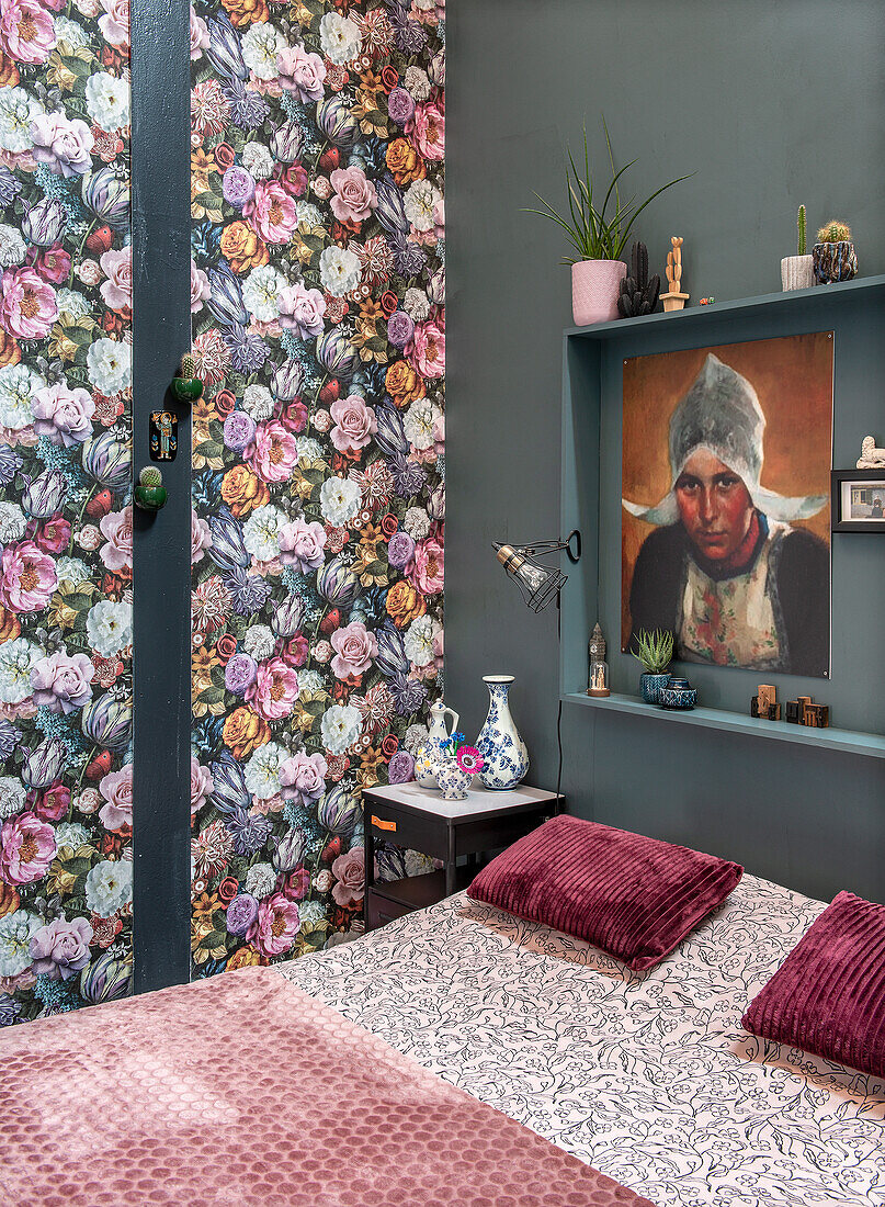 Bedroom with floral wallpaper, shelf and artwork on green wall