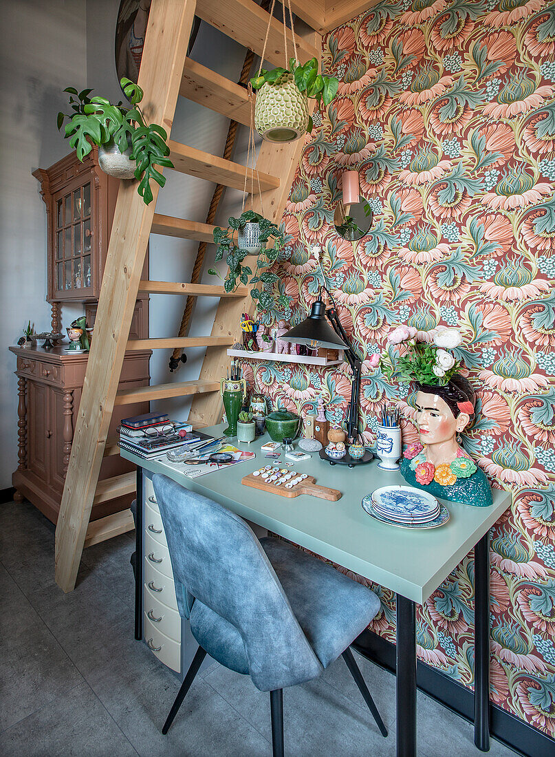 Creative workspace under ladder, patterned wallpaper