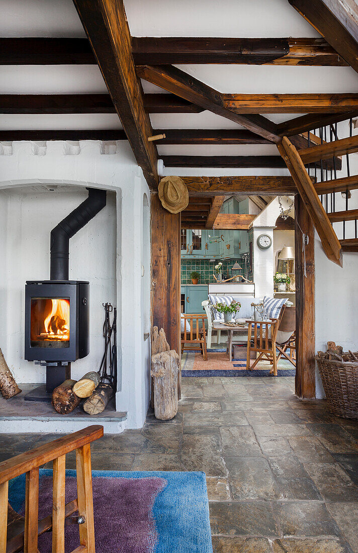 Living room with wood-burning stove and rustic wooden beams