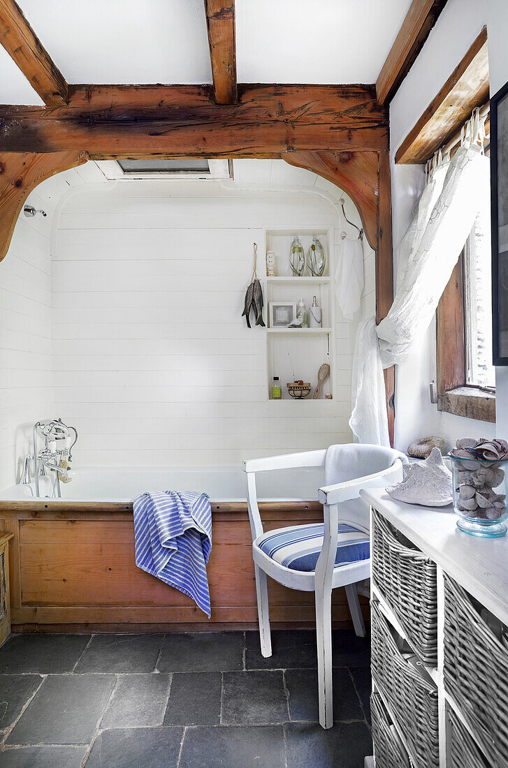 Rustic bathroom with exposed wooden beams and white walls