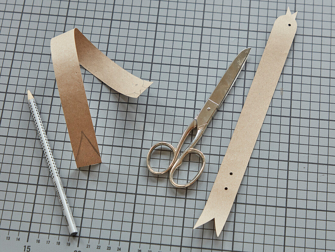 DIY bookmark made from cardboard, scissors and pencil on a cutting mat