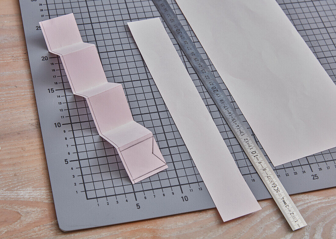 DIY project with pink paper strips, ruler and cutting mat