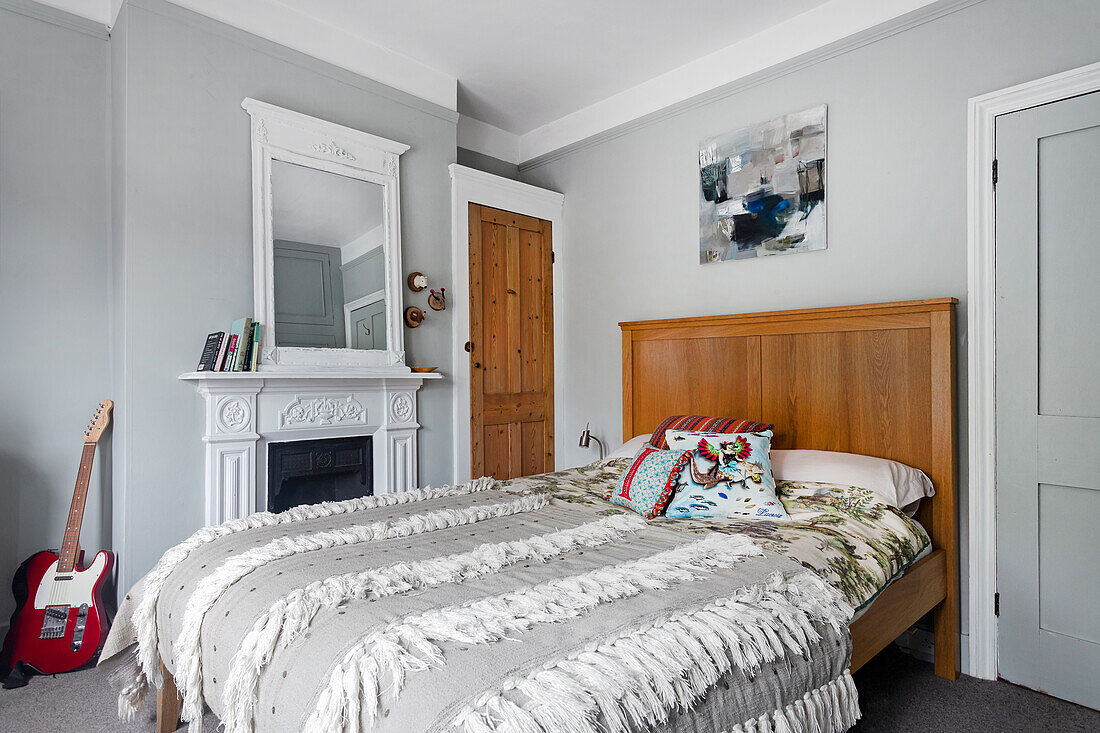 Bedroom with wooden bed, fireplace and electric guitar in the corner