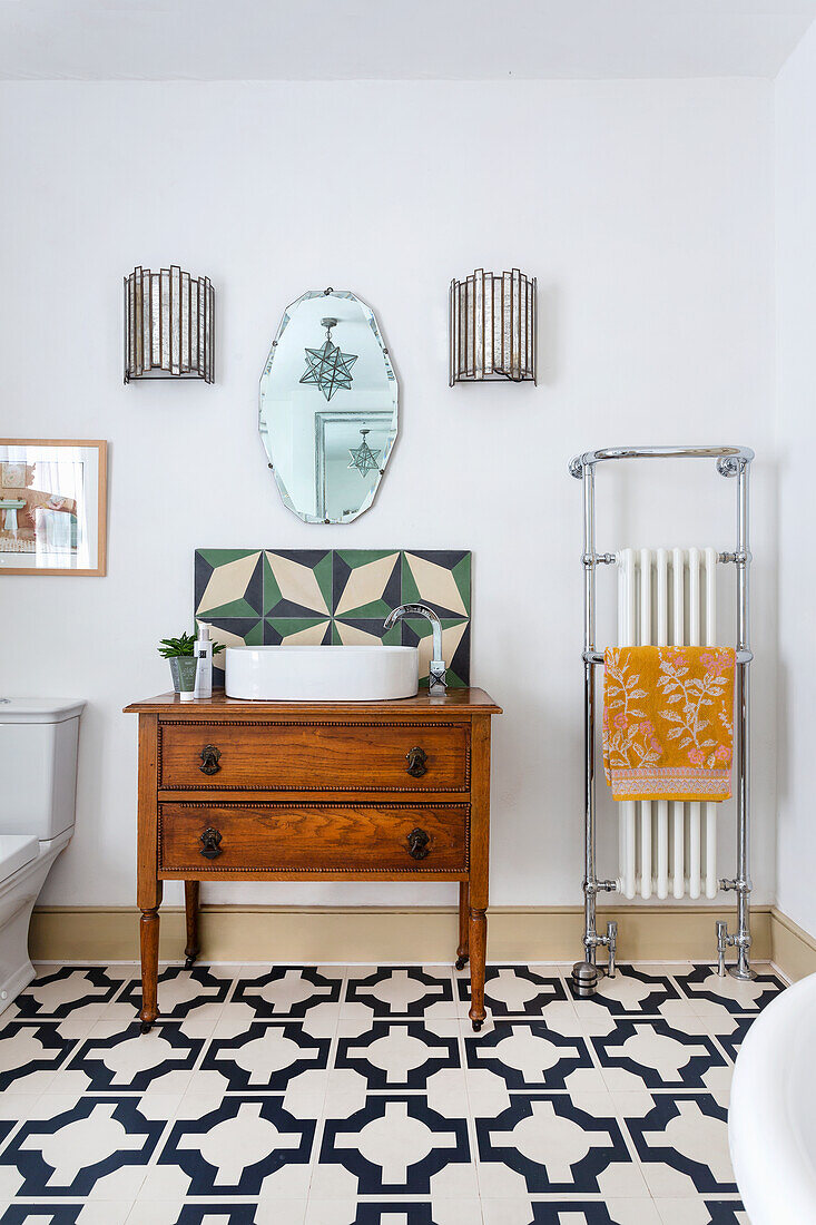 Retro bathroom with wooden dresser and geometric tile pattern