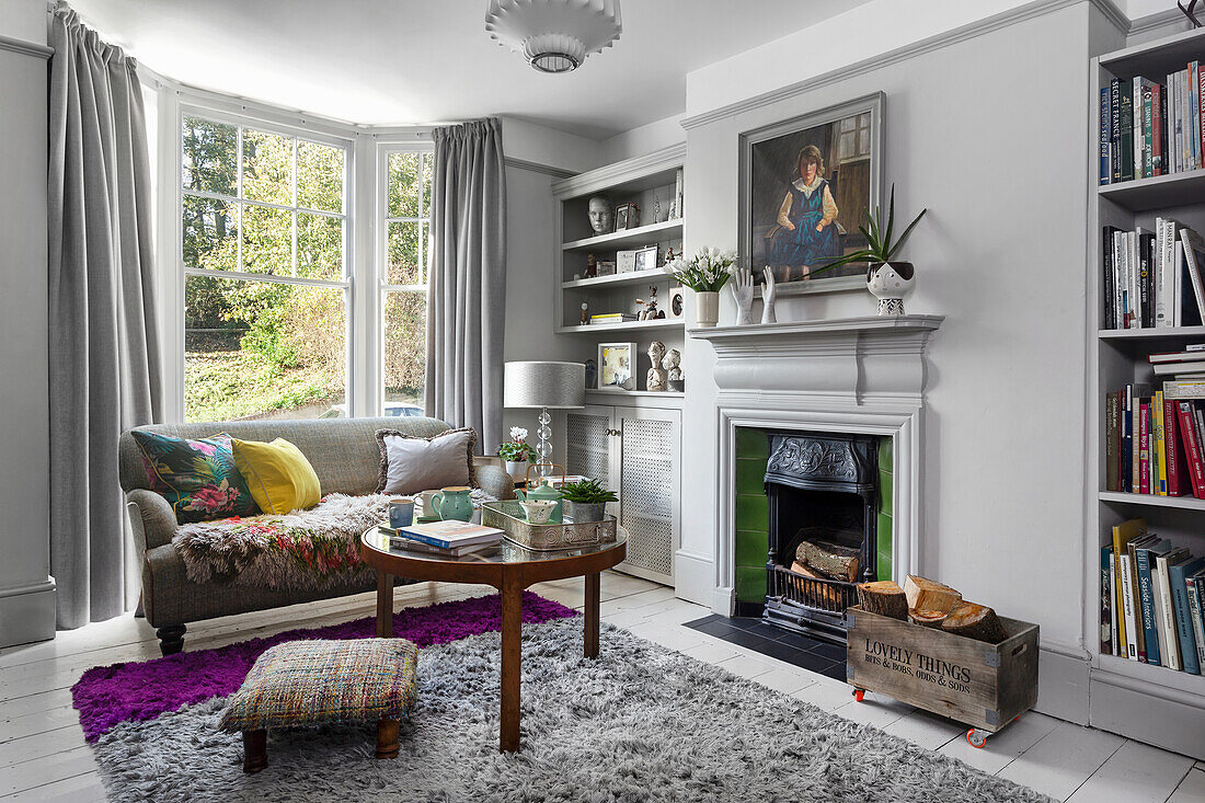 Living room with fireplace, grey sofa and bay window