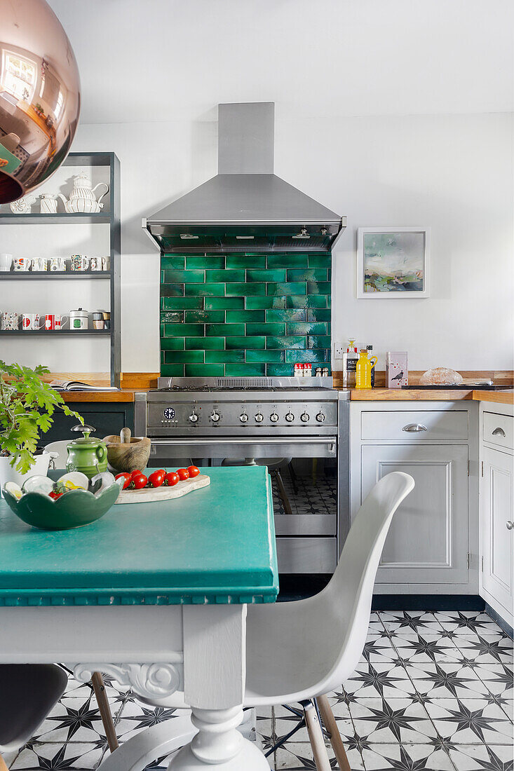 Kitchen with green wall tiles and tiled floor with star pattern